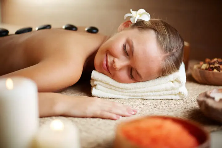 woman-lying-massage-table-with-hot-stones-her-back